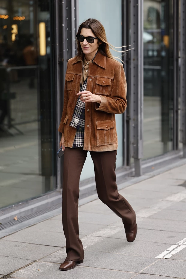 Γυναίκα που φοράει σουέτ τζάκε καφέ με καφέ παντελόνι και ίσιες καφέ μπότες.