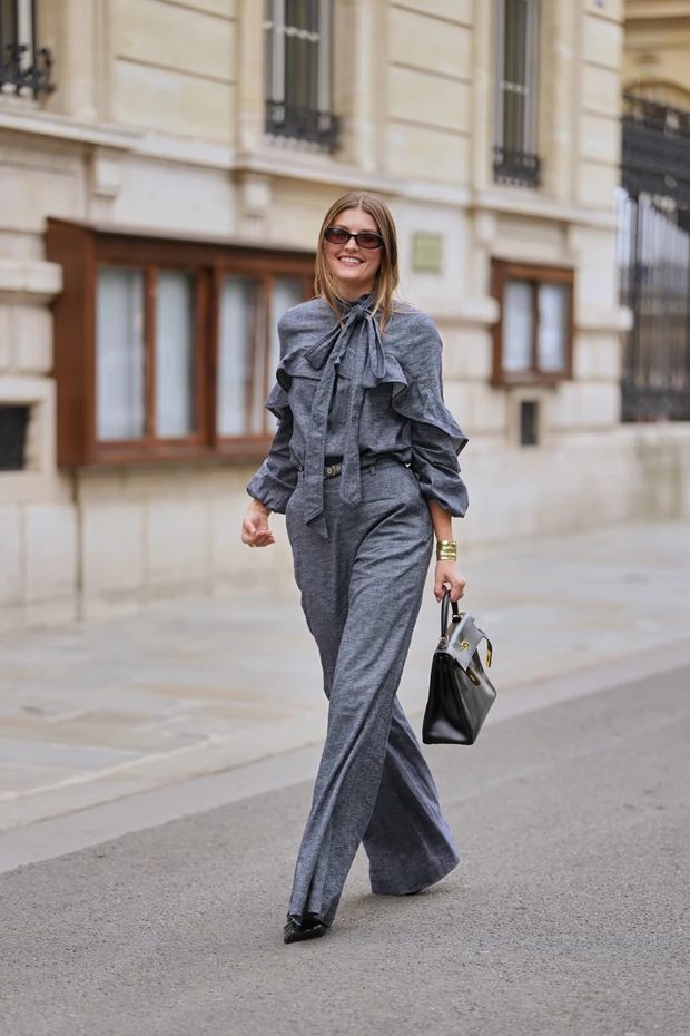 Γυναίκα με γκρι ψηλόμεσο wide leg παντελόνι και ασορτί μπλούζα σε tailored street style εμφάνιση.