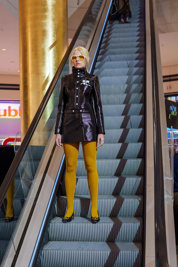 Golden Hall: Σύνολο σε στυλ '60s με λακαριστό ύφασμα, μαζεμένα μαλλιά και κίτρινους φακούς στα γυαλιά.