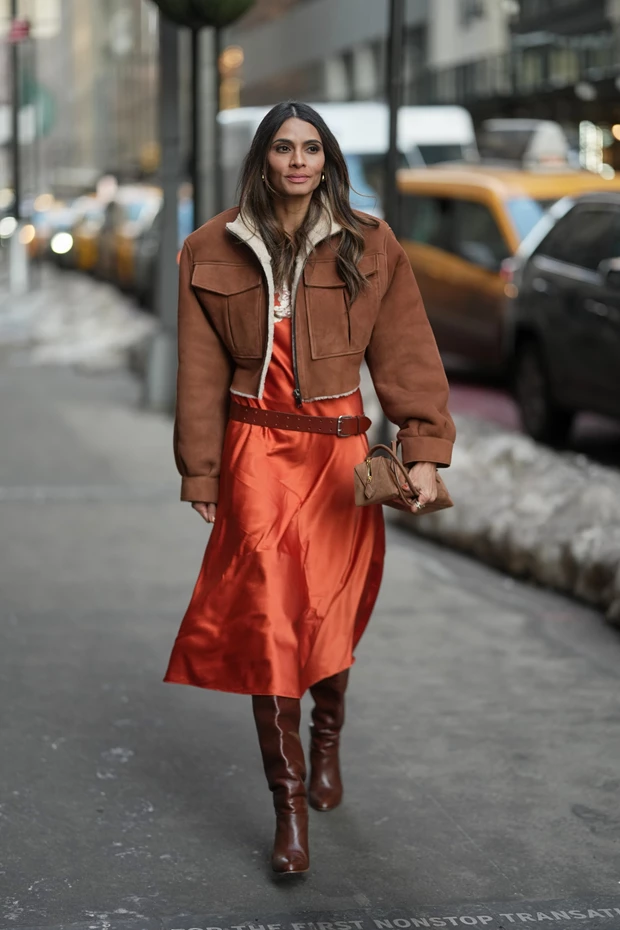 Γυναίκα σε δρόμο της Νέα Υόρκης με πορτοκαλί slip dress, shearling jacket και μπότες.