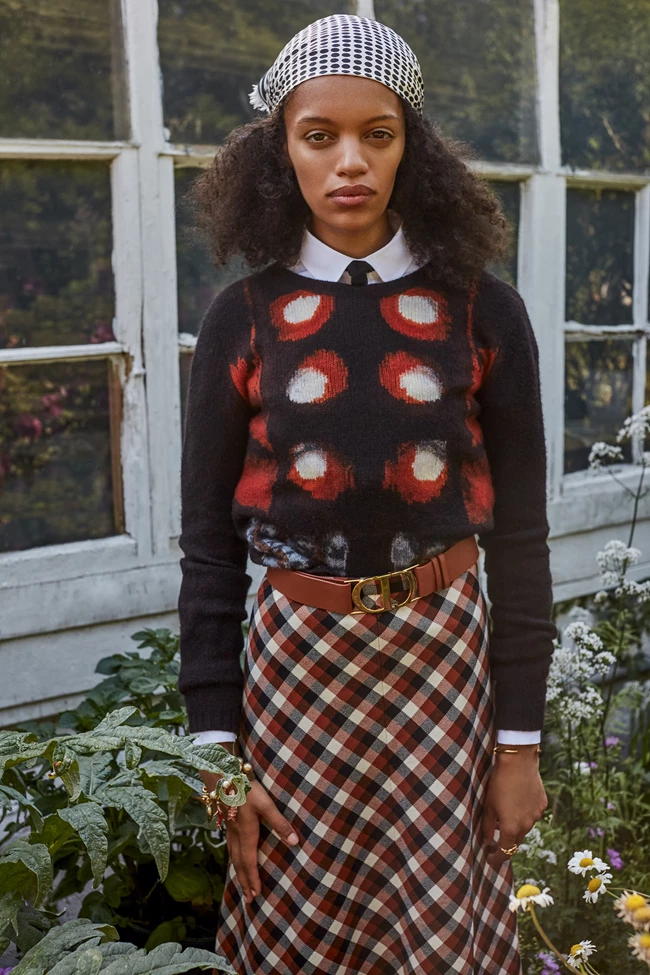 Πουλόβερ, πουκάμισο, φούστα, φουλάρι (φορεμένο στα μαλλιά), γραβάτα, ζώνη και βραχιόλια Dior, Dior Boutique.