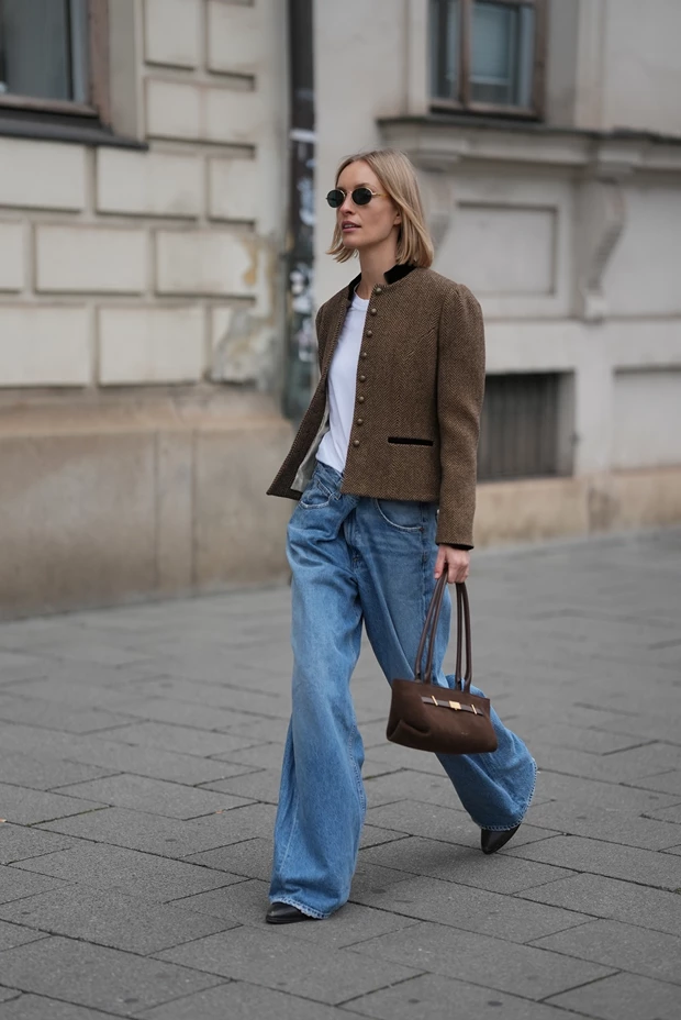 Γυναίκα στον δρόμο φοράει σουέτ τζάκετ, τζιν παντελόνι και κρατά σουέτ τσάντα που προσφέρεται για γυναικείο δώρο Χριστούγεννα 2025.