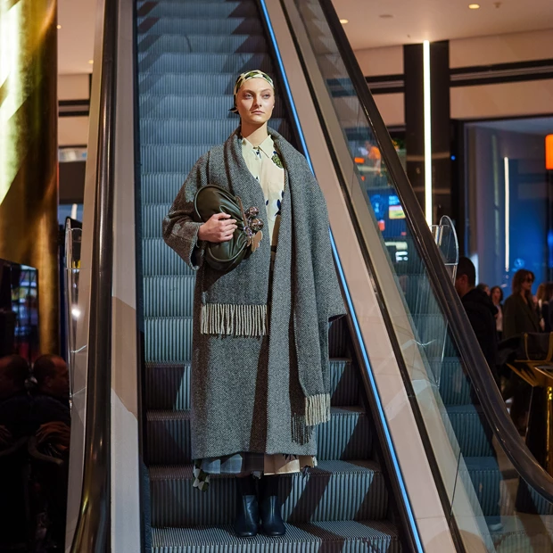 ο Stay Golden Fashion Show: Μοντέλο με φθινοπωρινό, άνετο (oversized) γκρι παλτό και μαντήλι στα μαλλιά.