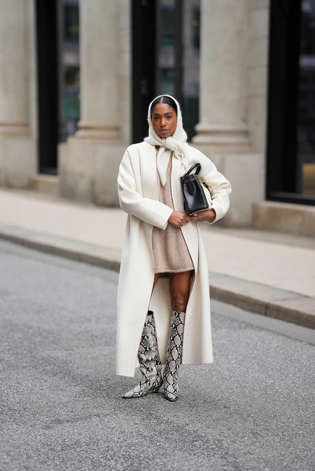Φορέματα στις χειμερινές εκπτώσεις: Γυναίκα με μίνι πλεκτό μπεζ φόρεμα, λευκό παλτό και snakeskin μπότες.