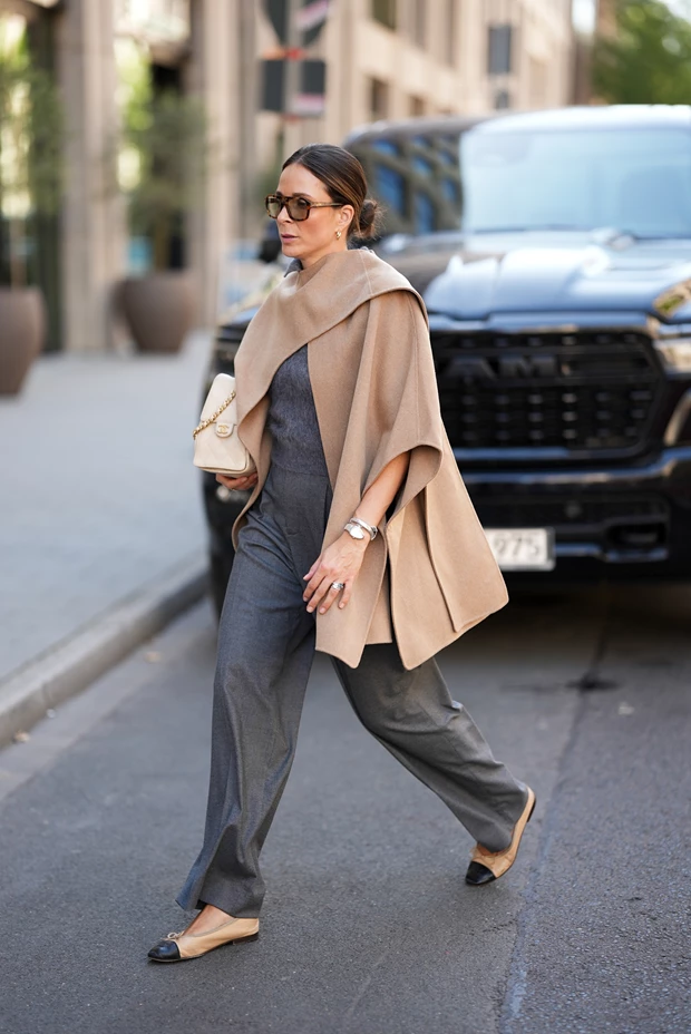 Street style: Γυναίκα με σύνολο σε ουδέτερα χρώματα - γκρι παντελόνι και μπεζ κάπα/πόντσο - βασικά κομμάτια capsule γκαρνταρόμπας.