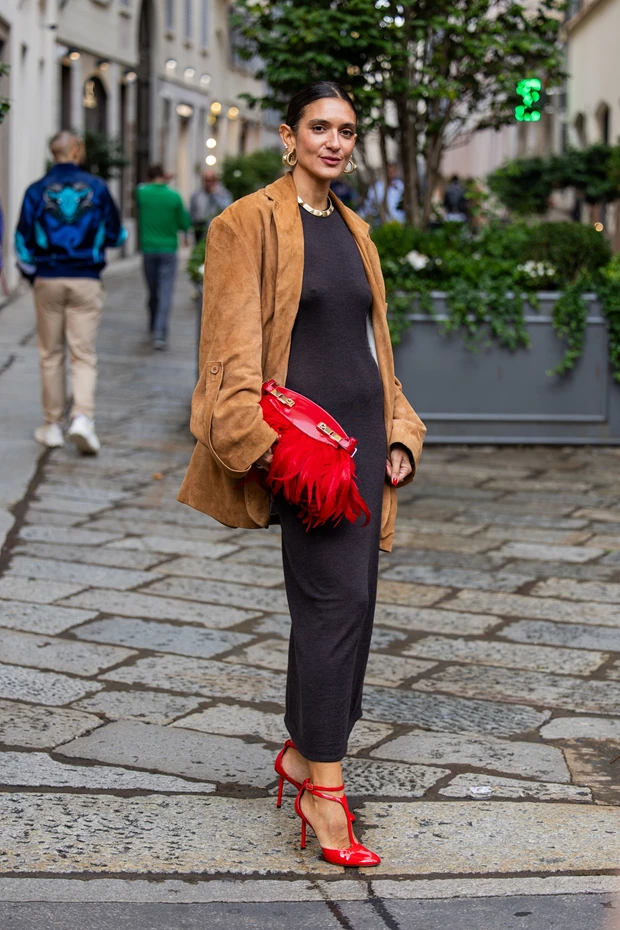 υναικεία street style εμφάνιση με μακρύ μαύρο φόρεμα, καμηλό σουέτ σακάκι, και έντονο κόκκινο  τσαντάκι με φτερά και ψηλοτάκουνα πέδιλα.