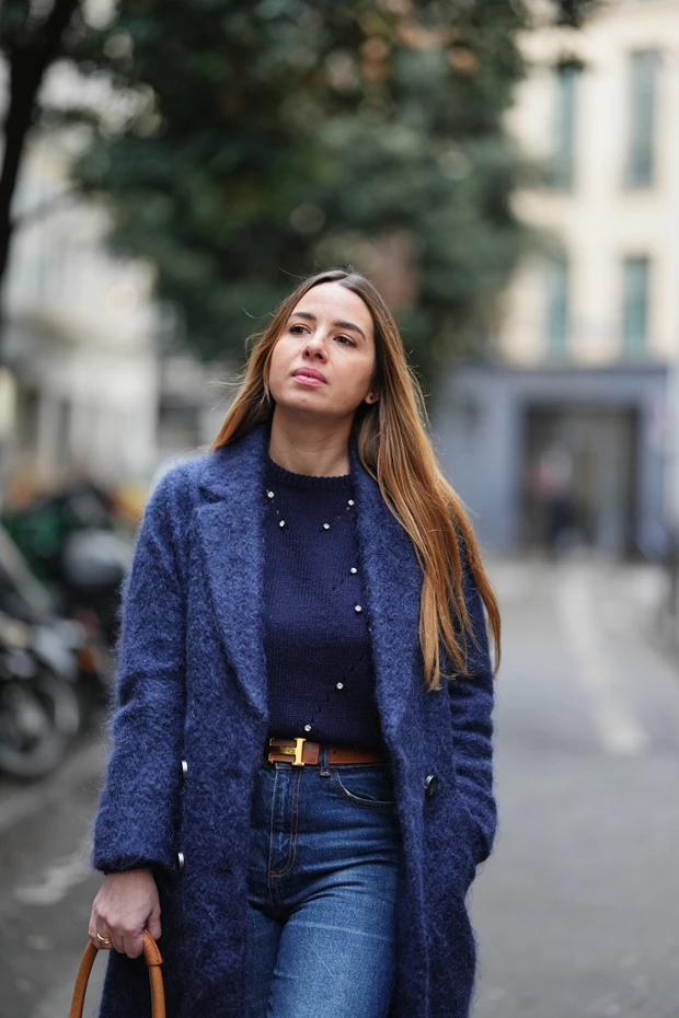 Η εικόνα δείχνει ένα μάλλινο παλτό σε royal blue, φορεμένο με navy blue πουλόβερ και κλασικό blue jeans, το οποίο τονίζεται με μια δερμάτινη καφέ ζώνη με χρυσή αγκράφα.