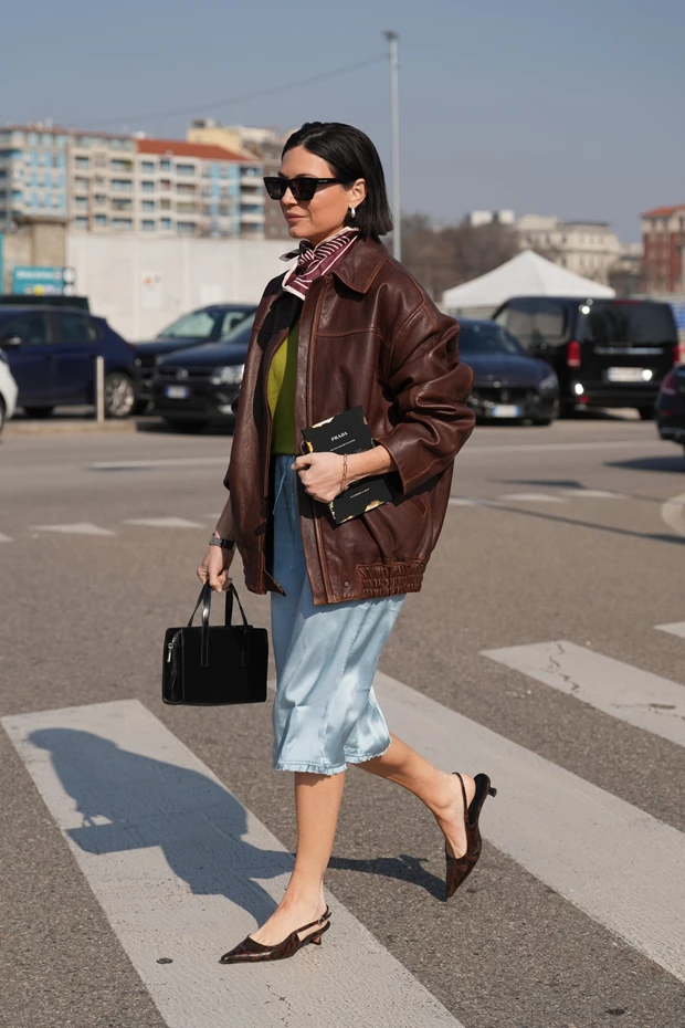 Street style look με καφέ δερμάτινο jacket και σατέν midi φούστα για κομψές ανοιξιάτικες εμφανίσεις