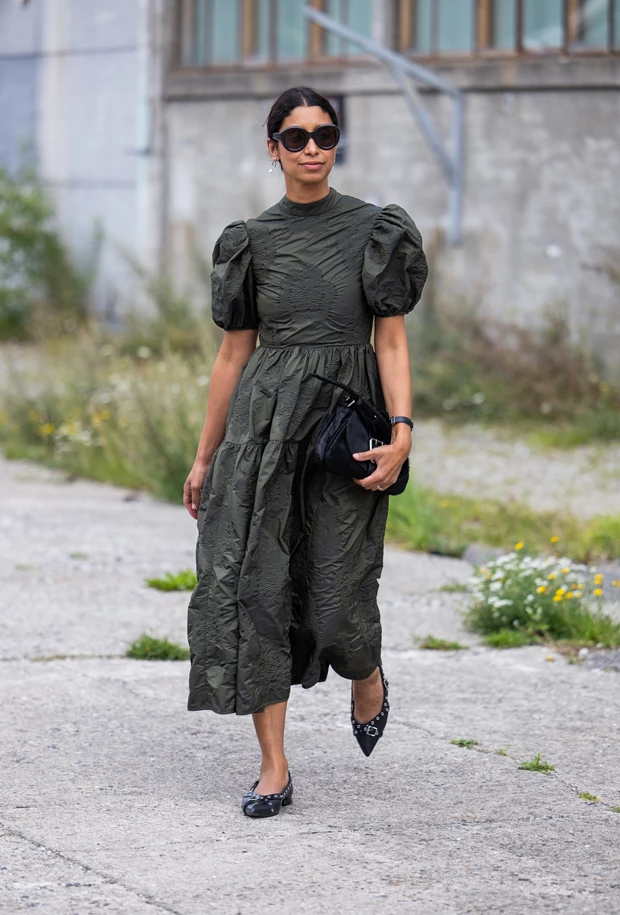 Γυναίκα με πράσινο μίντι φόρεμα και μαύρες μυτερές μπαλαρίνες σε street style look