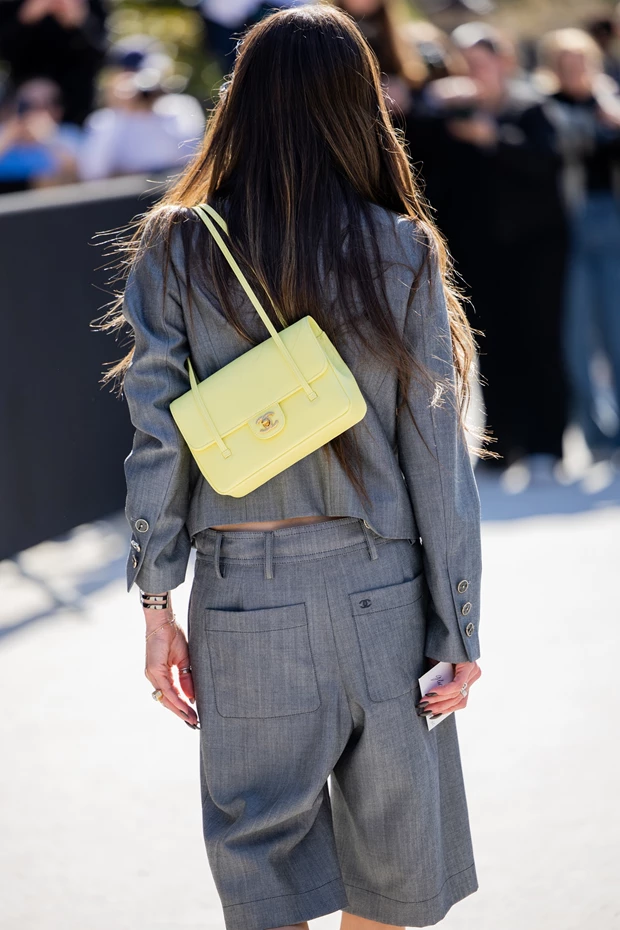 Κίτρινη τσάντα ώμου street style σε γκρι κοστούμι, τάση χρωμάτων τσάντες άνοιξη 2026