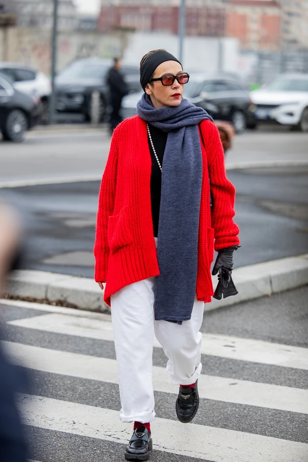 Last Minute δώρα για γυναίκες: Γυναίκα στον δρόμο με μακρύ κασκόλ και κόκκινη ζακέτα.