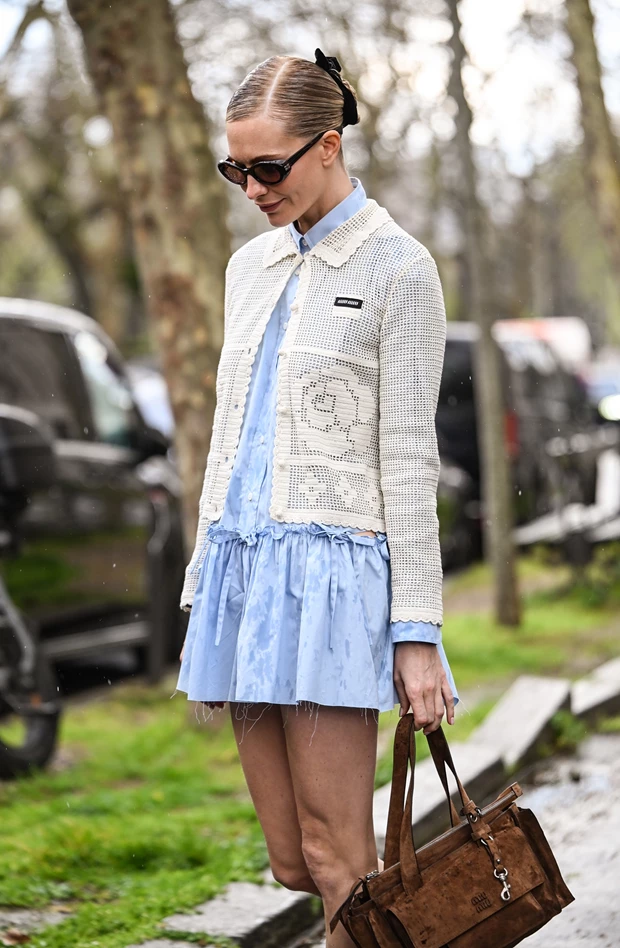 πλεκτή ζακέτα σε λευκό χρώμα με διακριτική πλέξη και κουμπιά, φορεμένη πάνω από γαλάζιο φόρεμα, street style άνοιξη 2026
