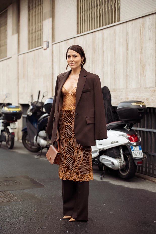 Καφέ κοστούμι με φαρδύ παντελόνι φορεμένο με κροσέ/δαντελένιο φόρεμα από μέσα.