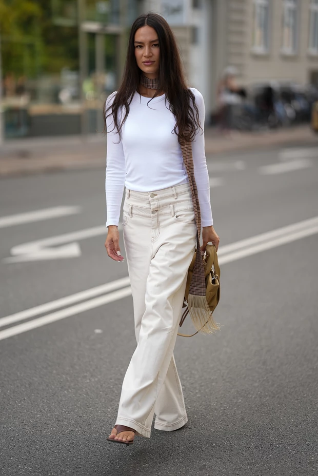 Minimal ανοιξιάτικο look με λευκό τζιν παντελόνι, λευκό μακρυμάνικο top και καφέ δερμάτινα thong sandals (flip flops).