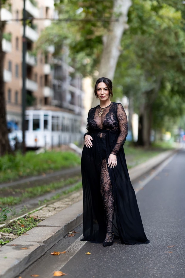 Γυναίκα στον δρόμο με μαύρο δαντελένιο φόρεμα και δαντελένιο καλσόν.