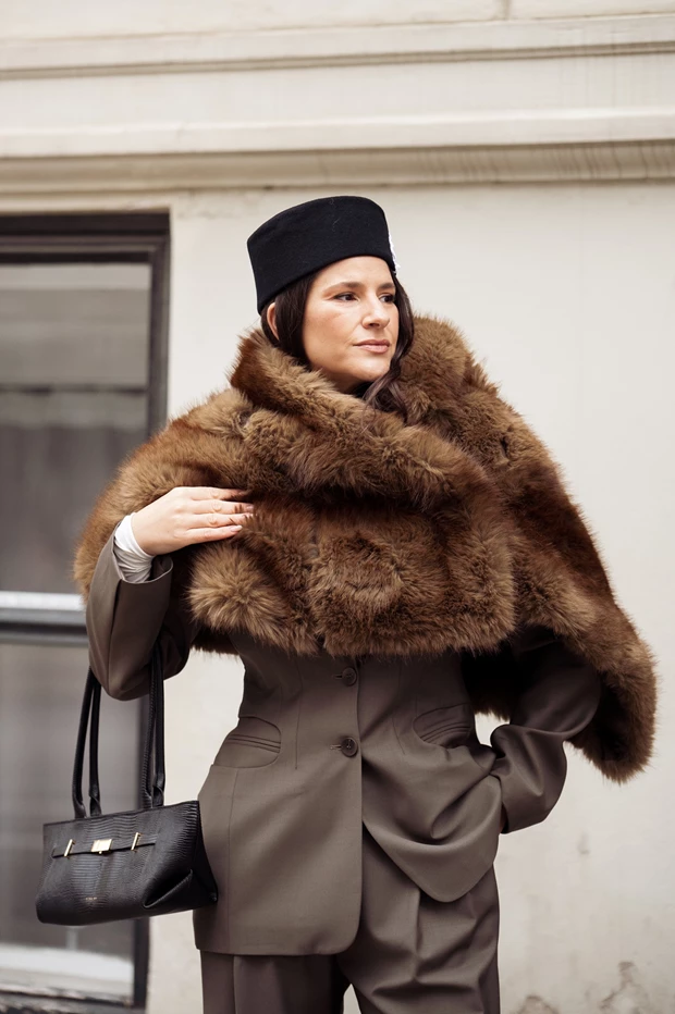 Glamoratti τάση μόδας 2026: Γυναίκα με power suit και ογκώδη γούνα γύρω από τον λαιμό.