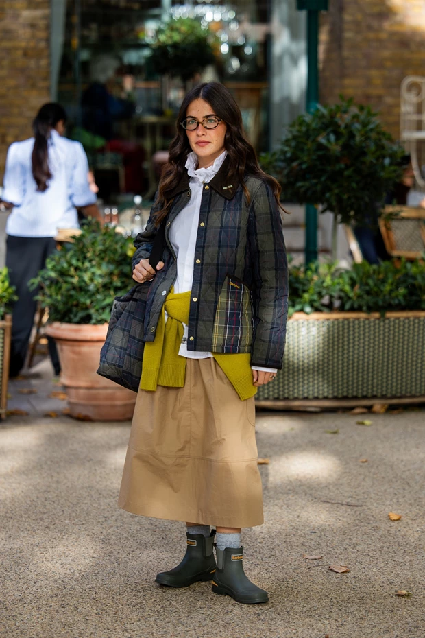 Χακί γαλότσες Barbour με μπεζ μίντι φούστα και καρό jacket