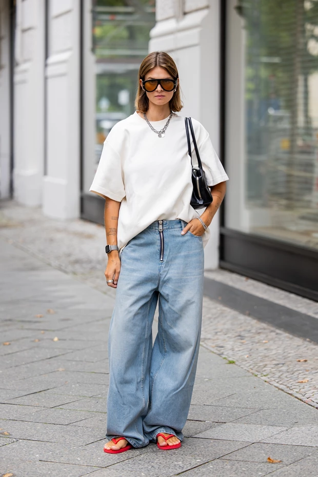 Γυναίκα σε street style look με τζιν, Τ-shirt και κόκκινες flip flops