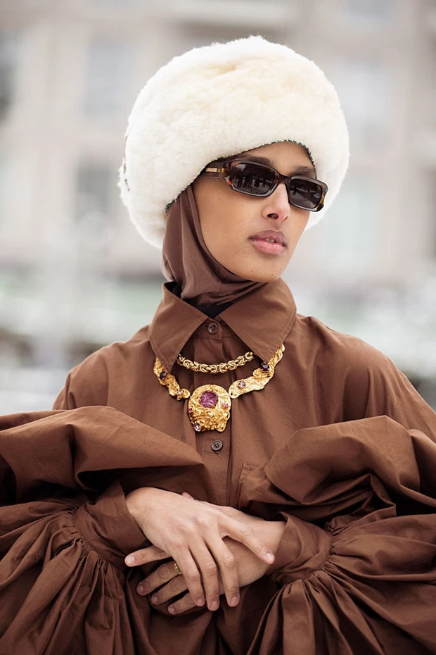 Street style Κοπεγχάγη: καφέ σύνολο με statement κολιέ, γούνινο καπέλο και γυαλιά ηλίου