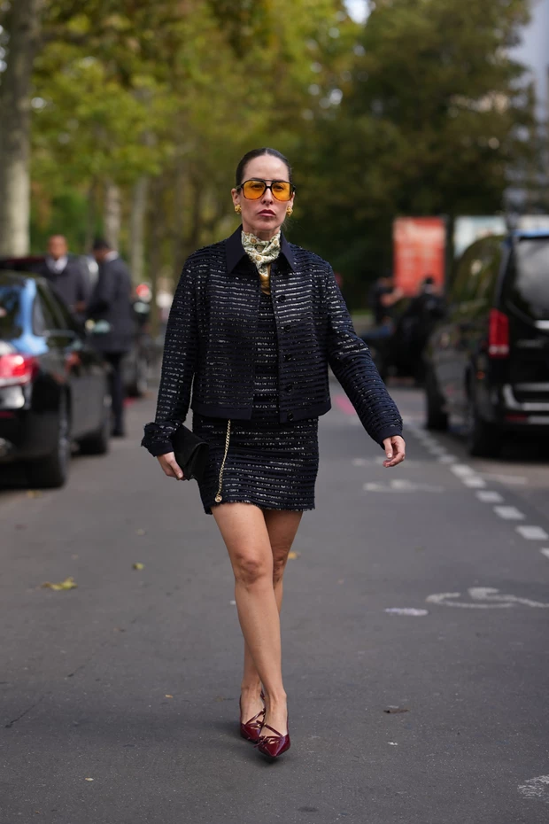 Γυναικείο μαύρο tweed ταγιέρ με διακριτική λάμψη, κίτρινα γυαλιά ηλίου και μπορντό γόβες, γιορτινό office look 2025.