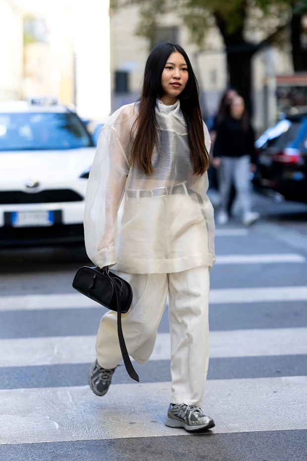 Κομψό φθινοπωρινό street style look με διαφανή μπλούζα, λευκό παντελόνι καιsneakers.