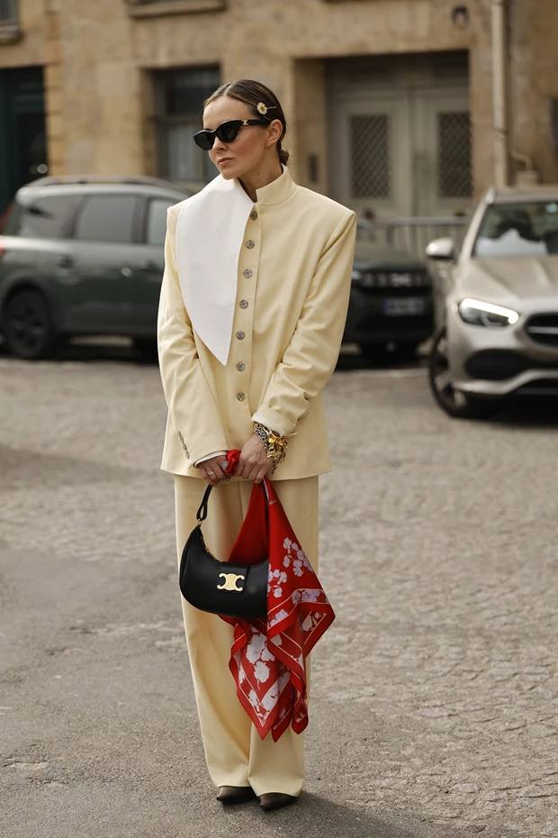Street style στο Παρίσι με μπεζ κοστούμι, μεταξωτό μαντήλι και statement αξεσουάρ