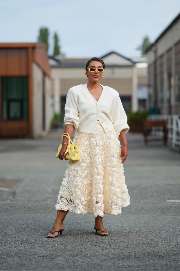 Γυναίκα με μαύρα thong sandals και midi φούστα με λουλούδια σε street style look από Copenhagen Fashion Week