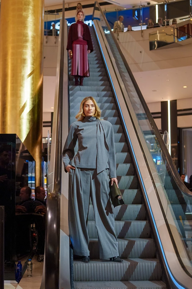 H Ισμήνη Παπαβλασοπούλου με γκρι, ανδρόγυνο, φαρδύ κοστούμι σε Stay Golden Fashion Show.