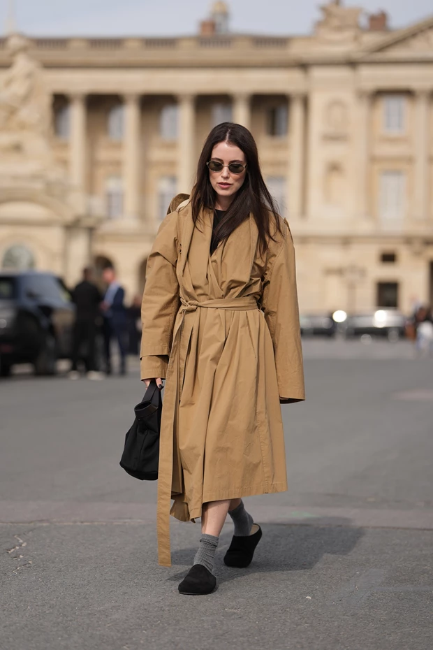 Chic χειμερινό look με μαύρα σουέντ clogs φορεμένα με γκρι μάλλινες κάλτσες και μακριά καμηλό καμπαρντίνα