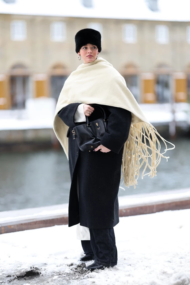 Street style Κοπεγχάγη: minimal μαύρο παλτό, oversized κασκόλ και γούνινο καπέλο