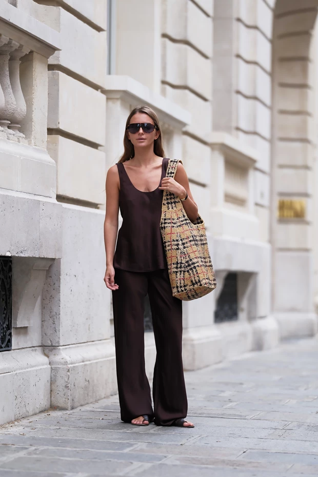 Γυναίκα με κομψό outfit σε σοκολακί και πλεκτή τσάντα
