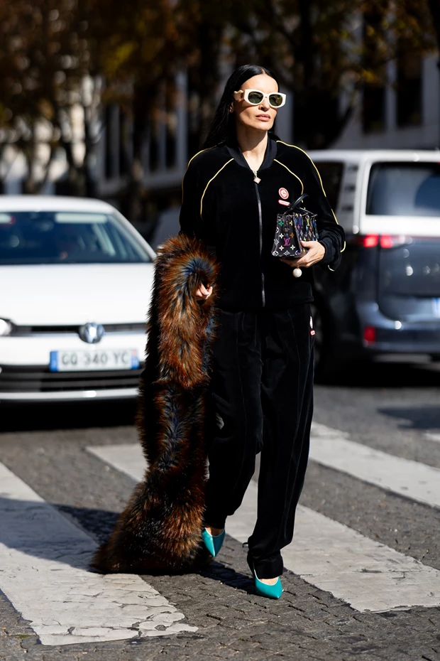 νατρεπτικό street style με μαύρη βελούδινη φόρμα, τιρκουάζ γόβες, λευκά cat-eye γυαλιά ηλίου και μια μακρά γούνινη εσάρπα με καφέ και μπλε αποχρώσει